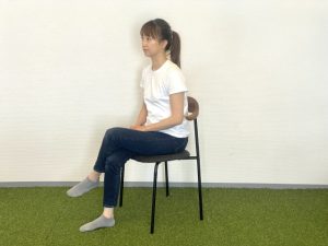足を組んで椅子に座る